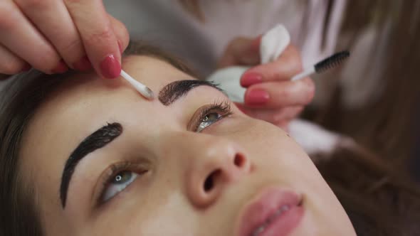 Caucasian woman lying down having her eyebrows dyed