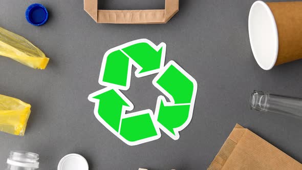 Green Recycle Symbol with Household Waste on Grey