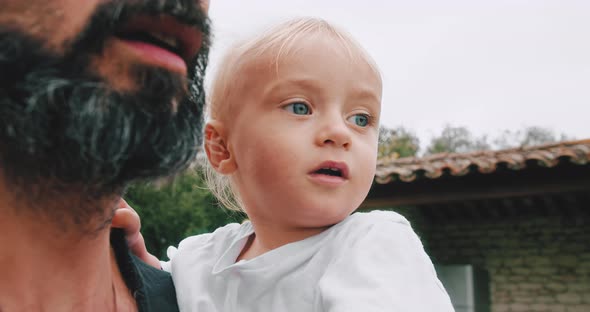 Young Father Holding in Hands His Cute Little Kid