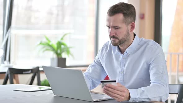 Online Payment By Young Man on Laptop in Office 