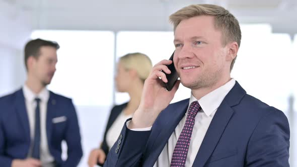 Portrait of Focused Businessman Talking on Smartphone in Office