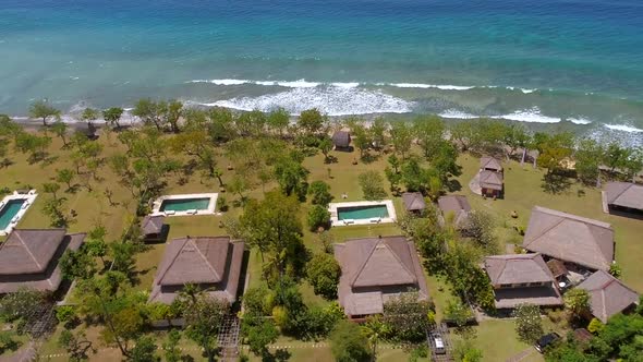 Aerial view of luxury bungalows near the coast of Bali island, Indonesia.