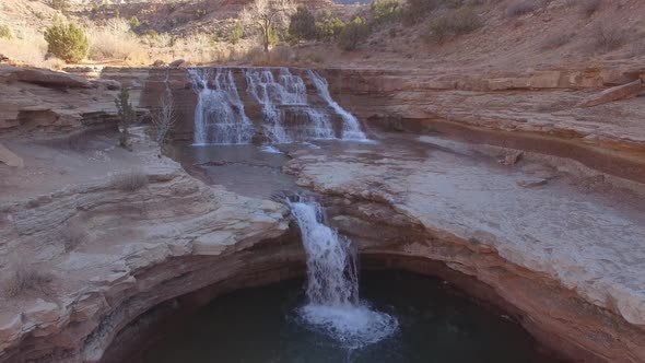 Aerial view flying over desert waterfall in Utah