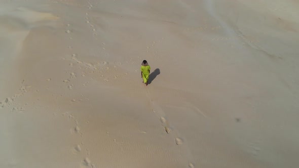 Aerial View of Woman Walking on Sand Dune