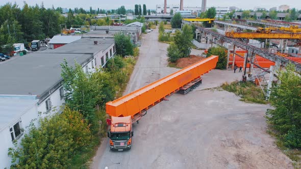 Transporting Orange Parts of Lifting Cranes on the Truck From the Plant