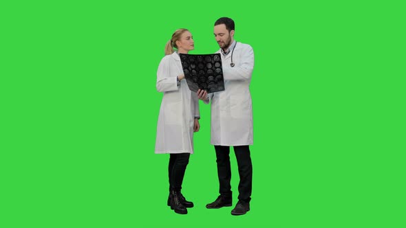 Doctors Examine Xray and Discuss Successful Result of Operation on a Green Screen, Chroma Key