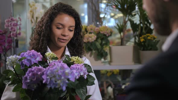 Young Florist Advising Buyer Flowering Plant