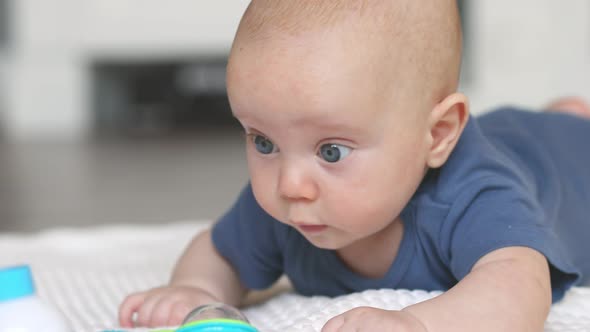 4 Months Baby Infant Lying on Stomach on Floor in Living Room Trying to Crawl