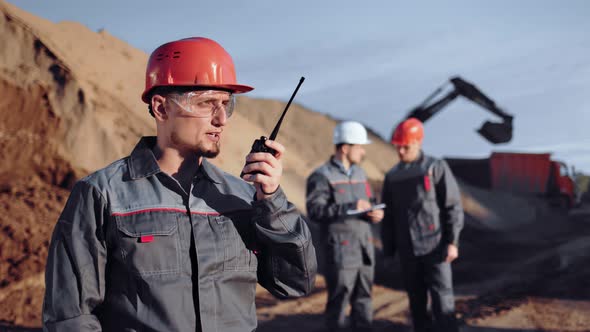 Male Industrial Engineer Talking Using Walkie Talkie at Construction Site Medium Shot