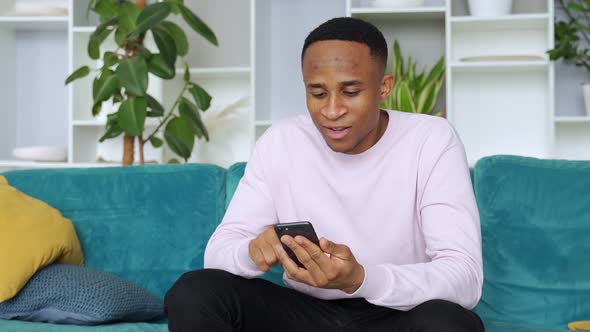 Black Man Winner Holding Smartphone Feeling Euphoric with Mobile Online Bet Bid Game Win