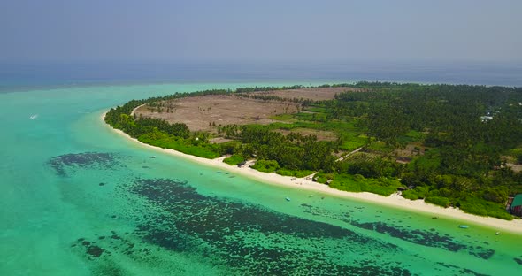 Tropical above island view of a sandy white paradise beach and aqua turquoise water background 