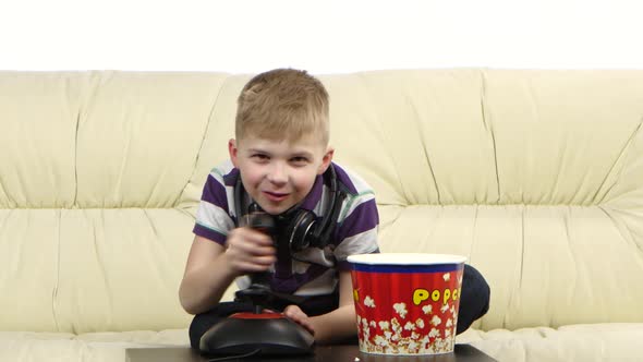 Teen Plays with Joystick in Online Game and Eats Popcorn