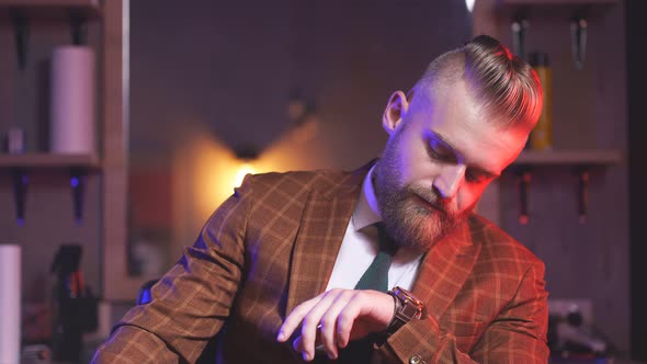 Self-confident Brutal Male in Tuxedo Is in Contemplation Indoors