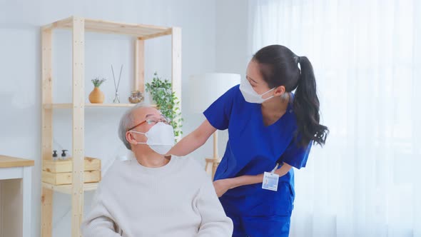 Asian young caregiver nurse take care senior older male on wheelchair.