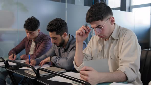 Frames Movement Group Diverse Young Students Sit in Row at Desk in Classroom Concentrated Write Test