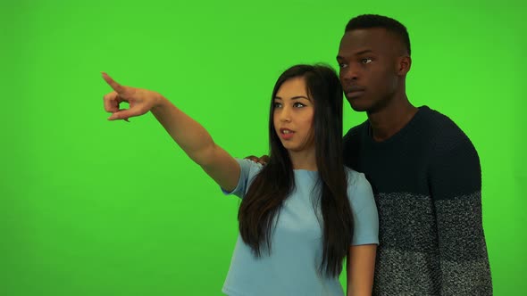 A Young Asian Woman and a Young Black Man Point at and Talk About Their Surroundings - Green Screen