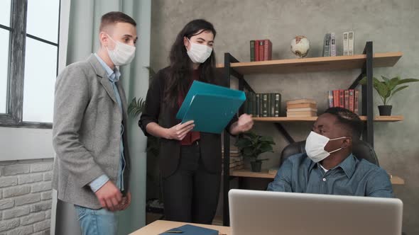 Colleagues Avoid a Handshake When Meeting in the Office and Greet Bumping Elbows. Multiracial