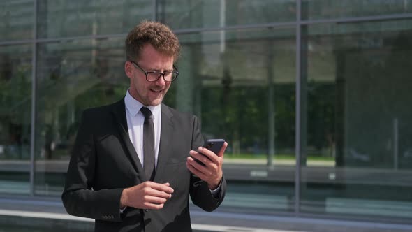 Businessman Is Talking By Videocall and Using Smartphone on Street