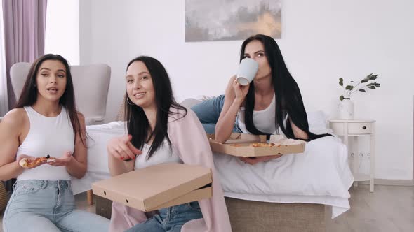 The Pretty Ladies Are Eating a Takeaway Pizza in Bedroom and Smiling