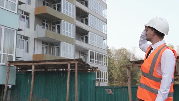 The foreman at the construction site puts on a white helmet.