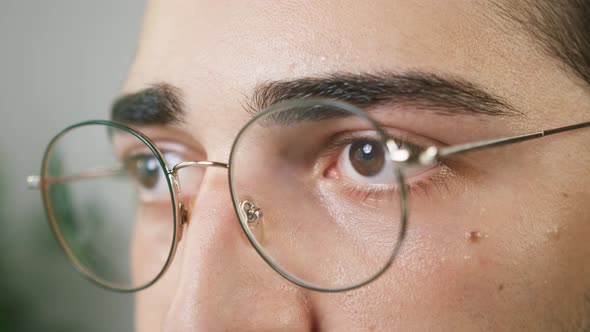 Brown Eyes of Young Brunette Man Wearing Circle Glasses Closeup Shooting Male Face with Eyewear Calm