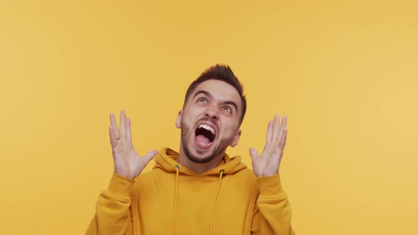 Expressive young man screaming and shouting over vibrant background.