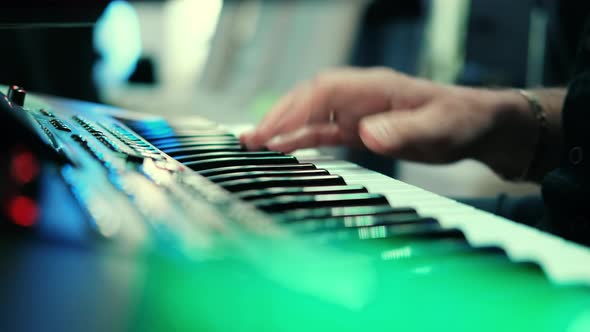 Musicians playing at a wedding. Man is playing synthesizer. Stage lights