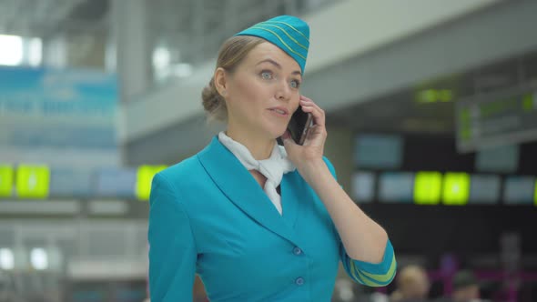 Portrait of Beautiful Happy Stewardess Hanging Up Smartphone and Leaving. Young Gorgeous Woman in