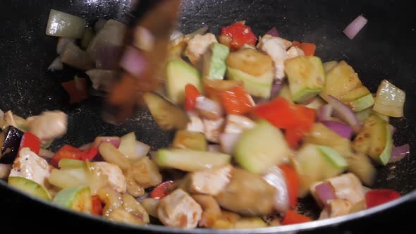 Hand Stiring Fried Chicken And Vegetables In A Wok