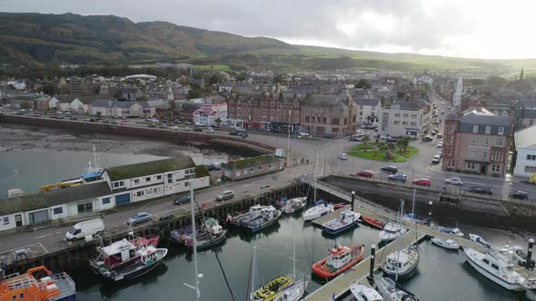 Fly over Campbeltown marina and old quay towards downtown Main Street