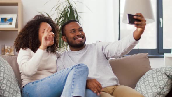 Happy Couple with Smartphone Taking Selfie at Home