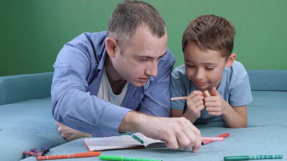 Happy Father and Son Spend Time Drawing with Colored Pencils