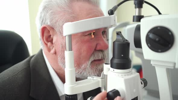 Examination of Elderly Man with Slit Lamp