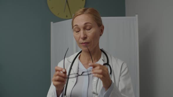 Portrait of Female Medical Doctor Expressing Fatigue Indoors