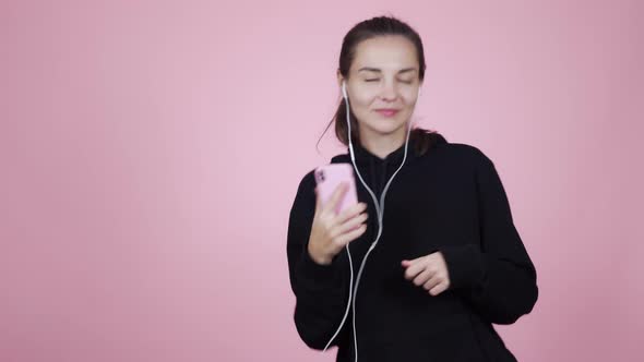 Young Woman Puts on Earphones, Listening Music and Enjoying Song, Isolated