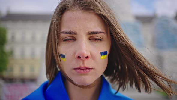 Portrait of Woman with Paintings of Ukrainian Flag on Cheeks