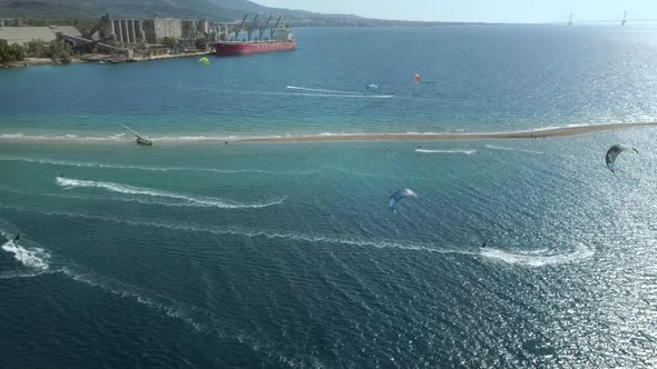 Aerial view of big group kitesurfing close to the shore.