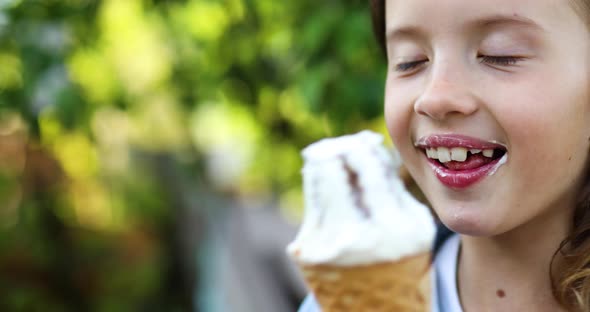 Cute Girl Eating Italian Ice Cream Cone Smiling While Resting in Park on Summer Day