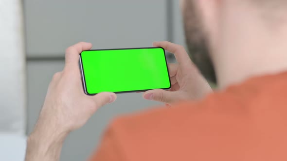 Young Man Watching Smartphone with Chroma Screen