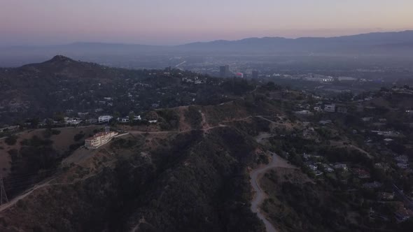 AERIAL: Over Hollywood Hills at Sunrise with View on Hills and the Valley and Power Lines in Los