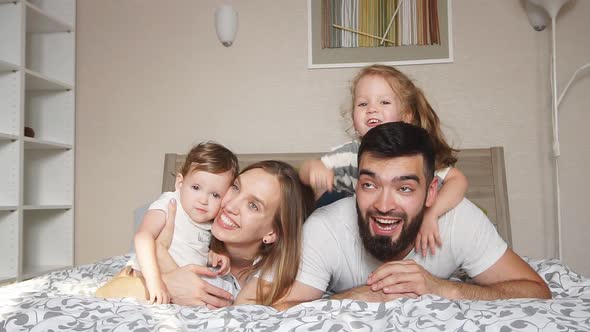 Happy Cheerful Friendly Family Lying on the Bed