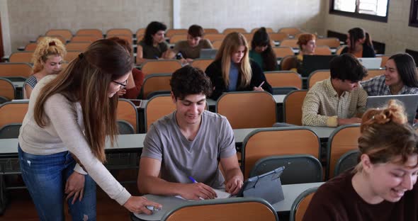 Mature teacher working with students inside classroom at school university