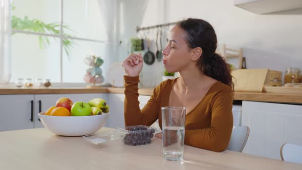 Latino attractive woman enjoy eating healthy foods in kitchen at home.