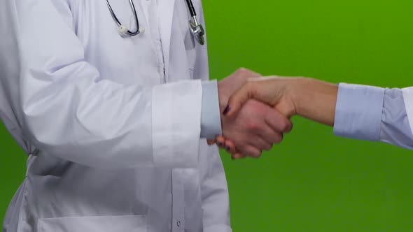 Handshake of Two Doctors in White Gowns. Green Screen. Close Up