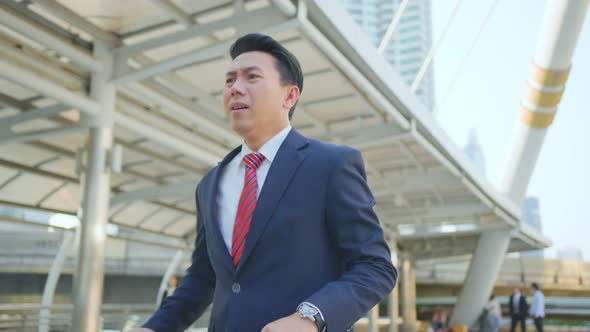 Asian manager smart businessman in hurry running outdoor going to work in office.