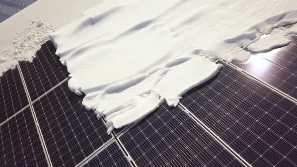 Closeup surface on a house roof covered with solar panels in winter with snow on top.