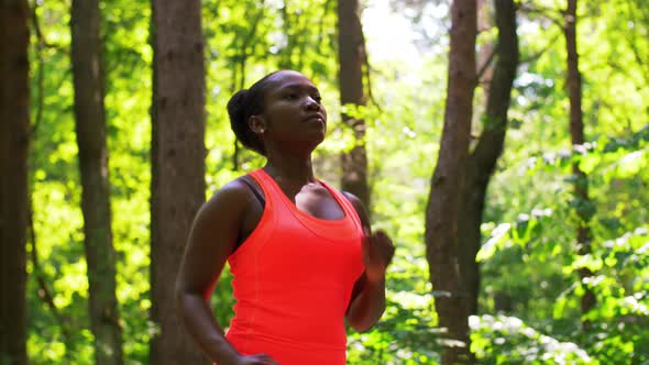 Young African American Woman Running in Forest