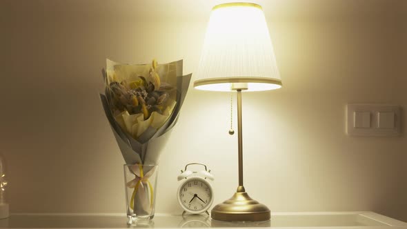 Console Table with Bouquet of Flowers Lit By a Table Lamp in the Living Room Apartment Decoration