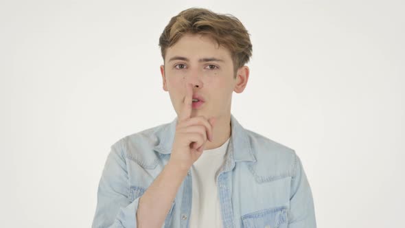 Young Man with Finger on Lips Silence Please