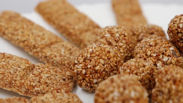 closeup view of Sesame ladoo and sticks made from sesame seeds